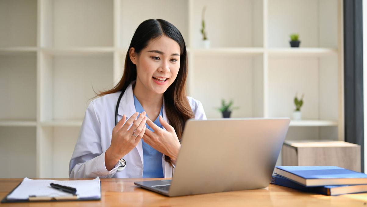Smart Asian female doctor is having online medical counseling wi